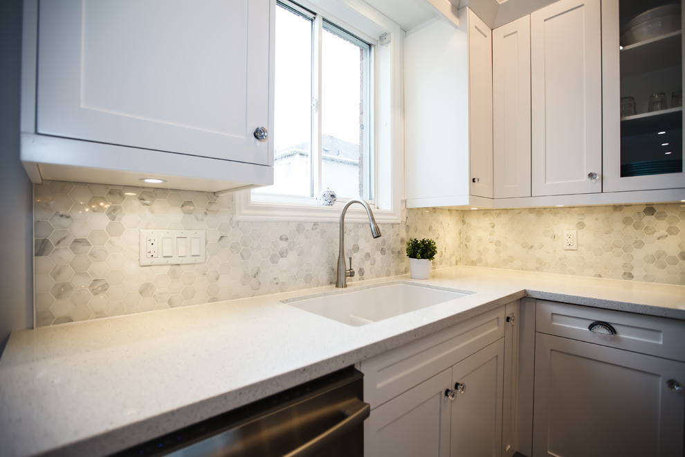 Inspiration for a mid-sized transitional galley dark wood floor eat-in kitchen remodel in Toronto with an undermount sink, shaker cabinets, white cabinets, granite countertops, white backsplash, stone tile backsplash, stainless steel appliances and an island