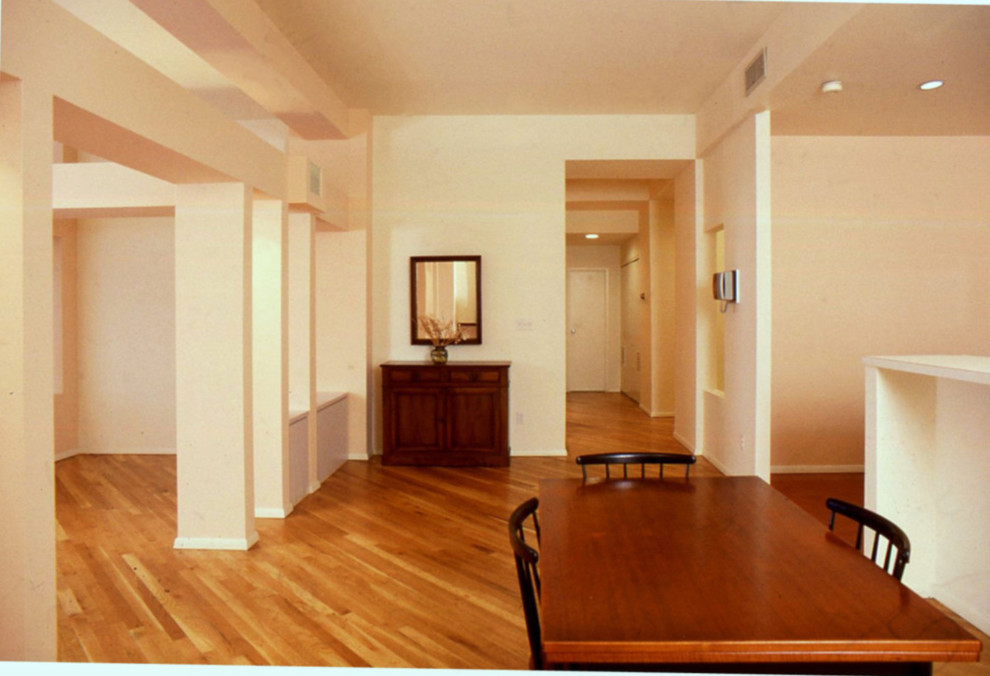 Large modern dining room in New York with light hardwood floors, pink walls and beige floor.