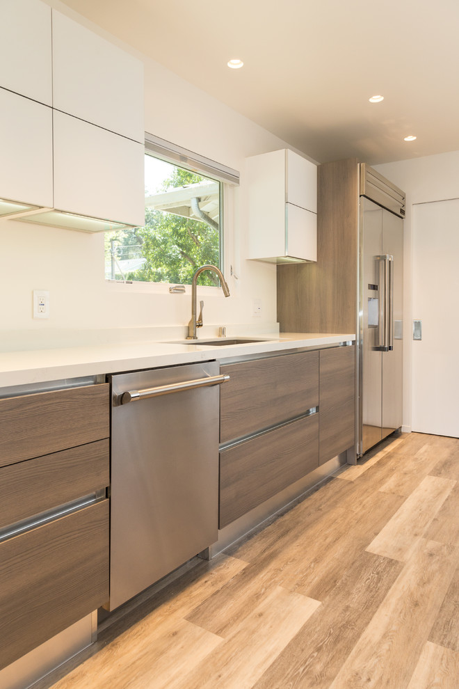 Inspiration for a mid-sized modern l-shaped eat-in kitchen in San Francisco with an undermount sink, flat-panel cabinets, light wood cabinets, quartz benchtops, white splashback, glass tile splashback, stainless steel appliances, laminate floors, with island and beige floor.