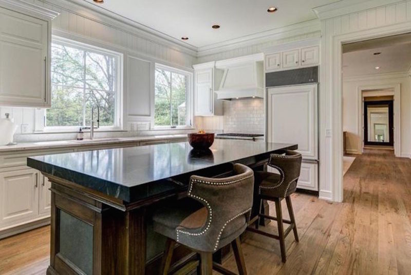 Eat-in kitchen - mid-sized transitional galley light wood floor and brown floor eat-in kitchen idea in Columbus with an undermount sink, raised-panel cabinets, white cabinets, marble countertops, white backsplash, subway tile backsplash, paneled appliances and an island