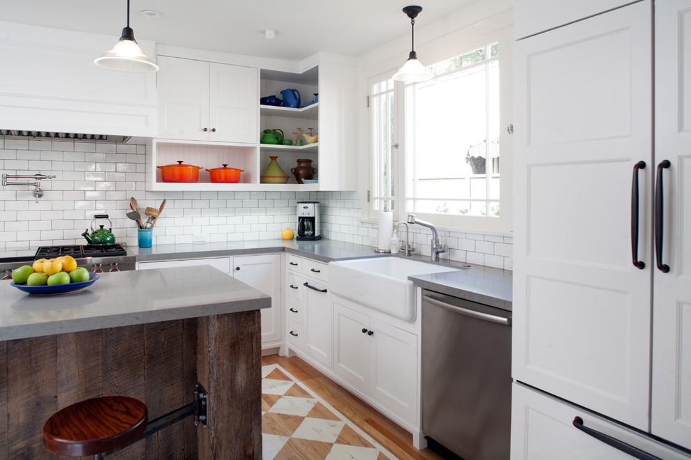 Photo of an arts and crafts u-shaped separate kitchen in Los Angeles with a farmhouse sink, beaded inset cabinets, white cabinets, quartz benchtops, white splashback, ceramic splashback, panelled appliances and painted wood floors.