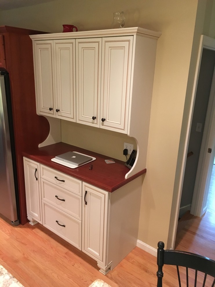 Transitional u-shaped light wood floor eat-in kitchen photo in Boston with an undermount sink, raised-panel cabinets, granite countertops, subway tile backsplash, stainless steel appliances and an island
