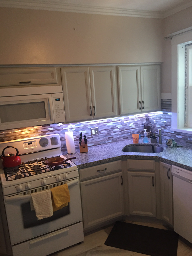 Kitchen - mid-sized transitional l-shaped ceramic tile and gray floor kitchen idea in St Louis with gray cabinets, recessed-panel cabinets, an undermount sink, granite countertops, multicolored backsplash, glass sheet backsplash, white appliances and multicolored countertops