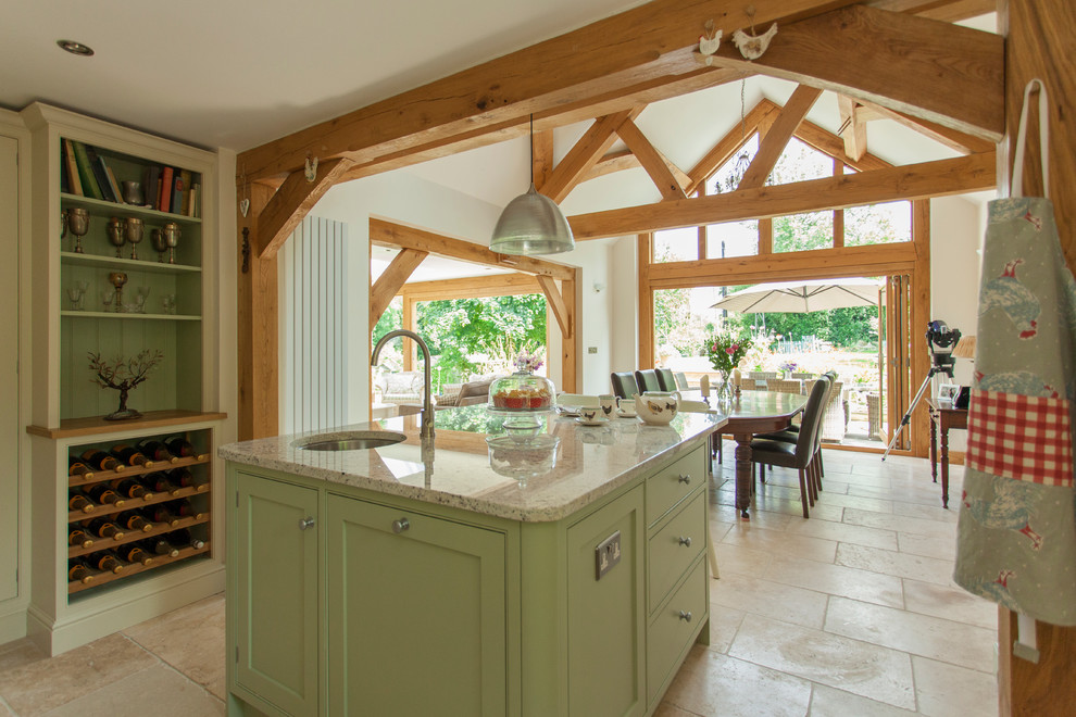 This is an example of a large traditional l-shaped eat-in kitchen in Gloucestershire with an integrated sink, shaker cabinets, green cabinets, granite benchtops, white splashback, glass sheet splashback, stainless steel appliances, travertine floors, with island, beige floor and green benchtop.
