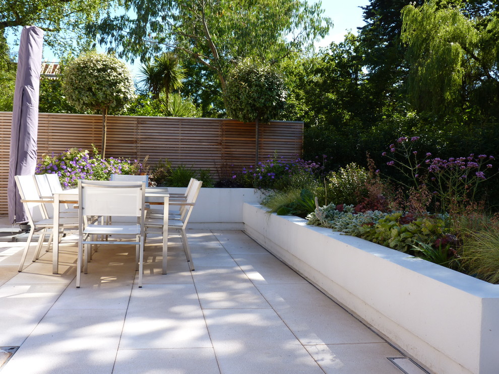 Photo of a mid-sized contemporary backyard partial sun garden in Hertfordshire.