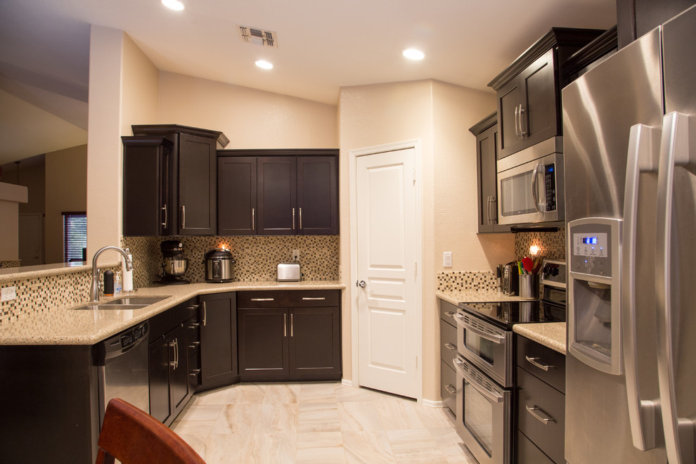 Inspiration for a mid-sized modern u-shaped porcelain tile eat-in kitchen remodel in Phoenix with an undermount sink, flat-panel cabinets, dark wood cabinets, quartzite countertops, multicolored backsplash, glass sheet backsplash, stainless steel appliances and no island