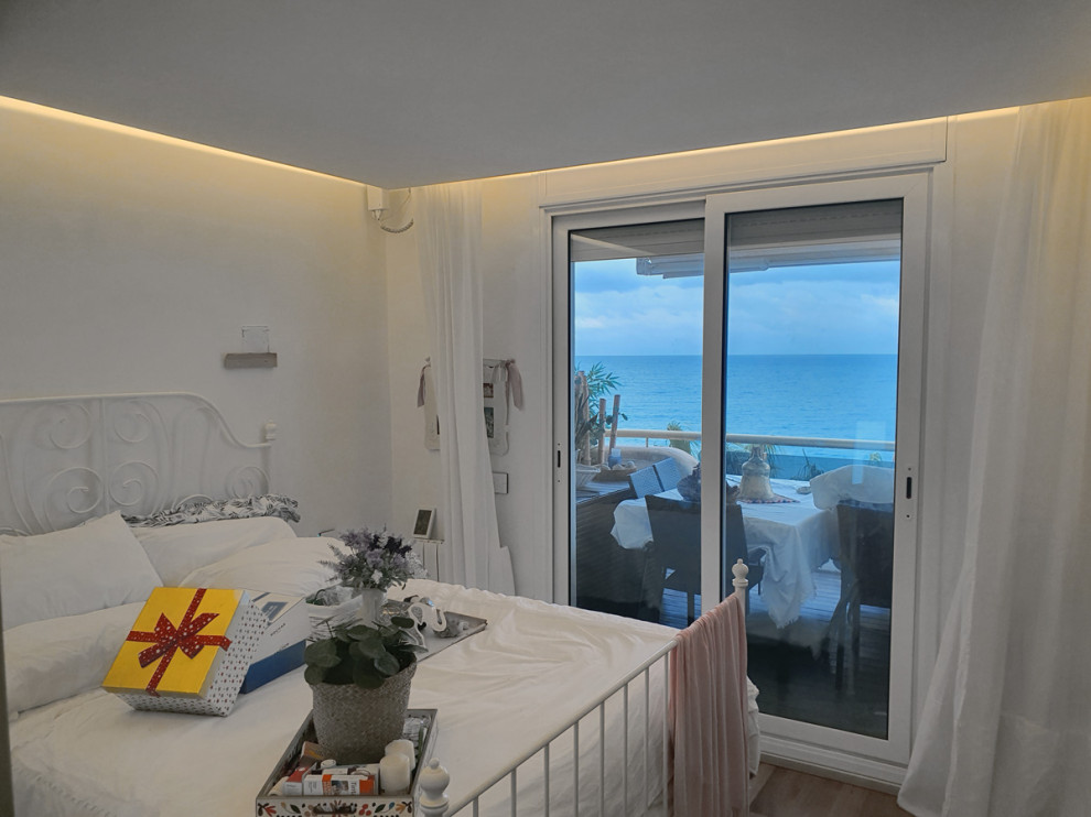 Immagine di una piccola camera matrimoniale mediterranea con pareti bianche