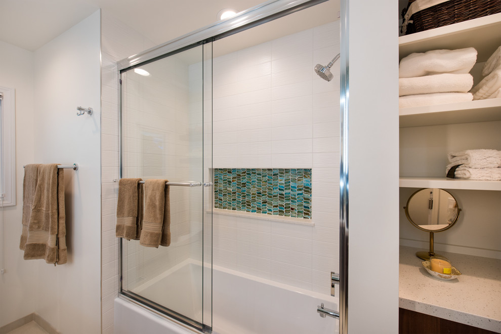 Photo of a mid-sized modern kids bathroom in Orange County with flat-panel cabinets, medium wood cabinets, an alcove tub, a corner shower, a bidet, multi-coloured tile, glass sheet wall, white walls, porcelain floors, an undermount sink, engineered quartz benchtops, beige floor and a sliding shower screen.