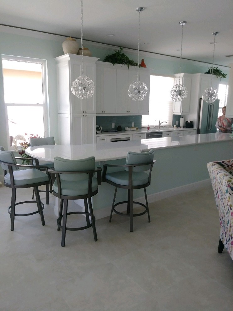 Transitional galley kitchen photo with shaker cabinets, white cabinets, quartz countertops, glass tile backsplash and stainless steel appliances