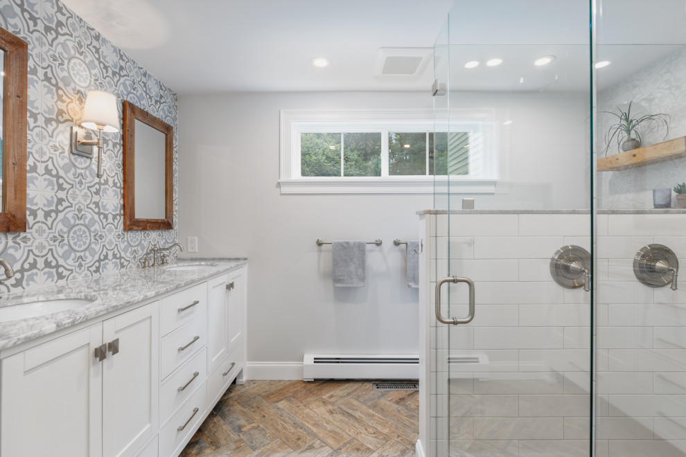 Design ideas for a large transitional master bathroom in Boston with shaker cabinets, white cabinets, a curbless shower, multi-coloured tile, porcelain tile, grey walls, porcelain floors, an undermount sink, marble benchtops, brown floor, a hinged shower door, white benchtops, a double vanity and a freestanding vanity.