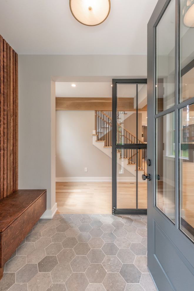 This is an example of a country foyer in Philadelphia with beige walls, ceramic floors, a single front door, a black front door, grey floor and wood walls.