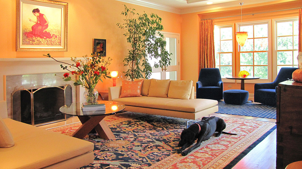 Photo of a contemporary formal living room in San Francisco with orange walls and a standard fireplace.