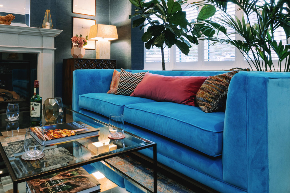 На фото: парадная, изолированная гостиная комната среднего размера в современном стиле с синими стенами, паркетным полом среднего тона, стандартным камином, фасадом камина из камня, коричневым полом и обоями на стенах без телевизора с