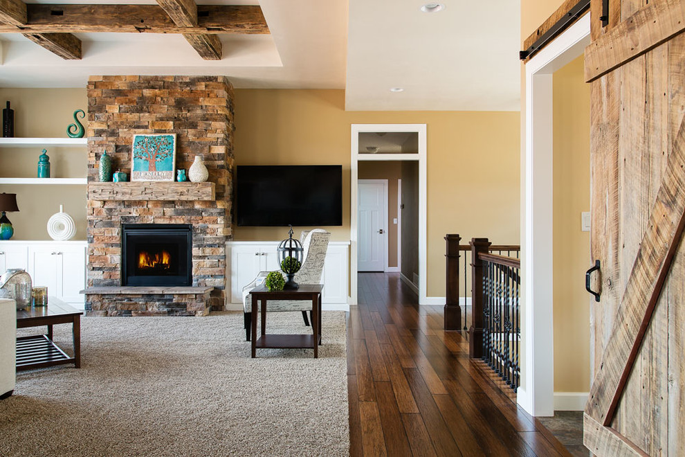 Large transitional open concept living room in Other with brown walls, carpet, a standard fireplace, a stone fireplace surround, a wall-mounted tv and grey floor.