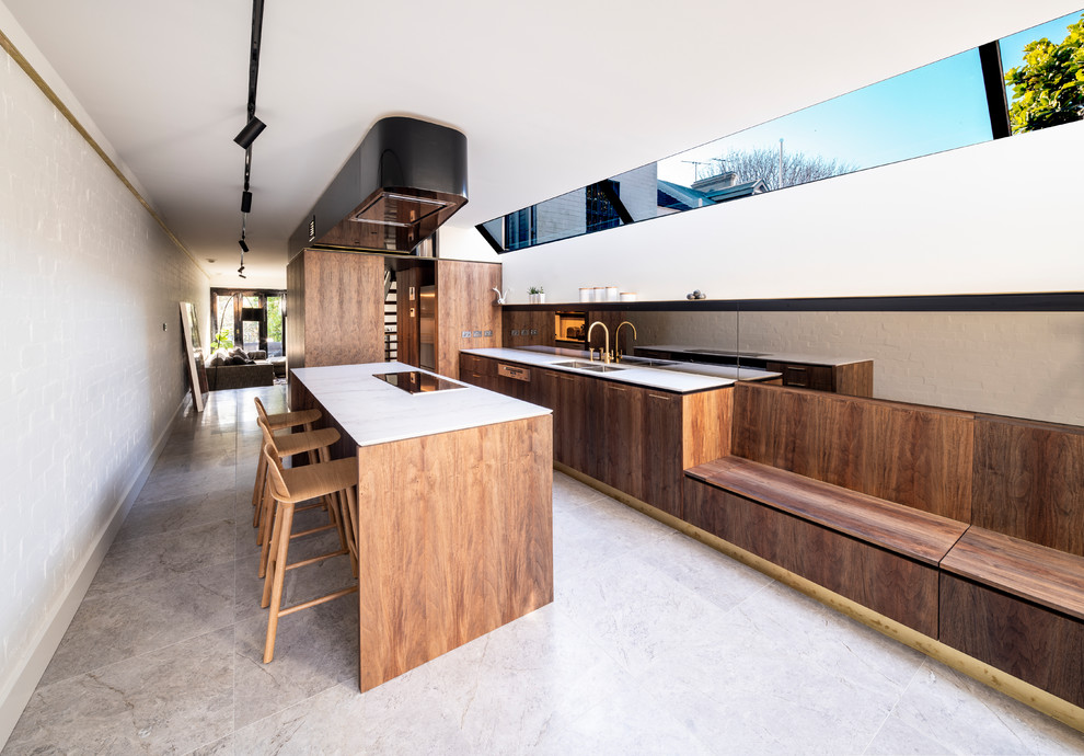 Inspiration for a modern galley kitchen in Sydney with flat-panel cabinets, brown cabinets, marble benchtops, metallic splashback, mirror splashback, with island, white benchtop, a double-bowl sink and panelled appliances.