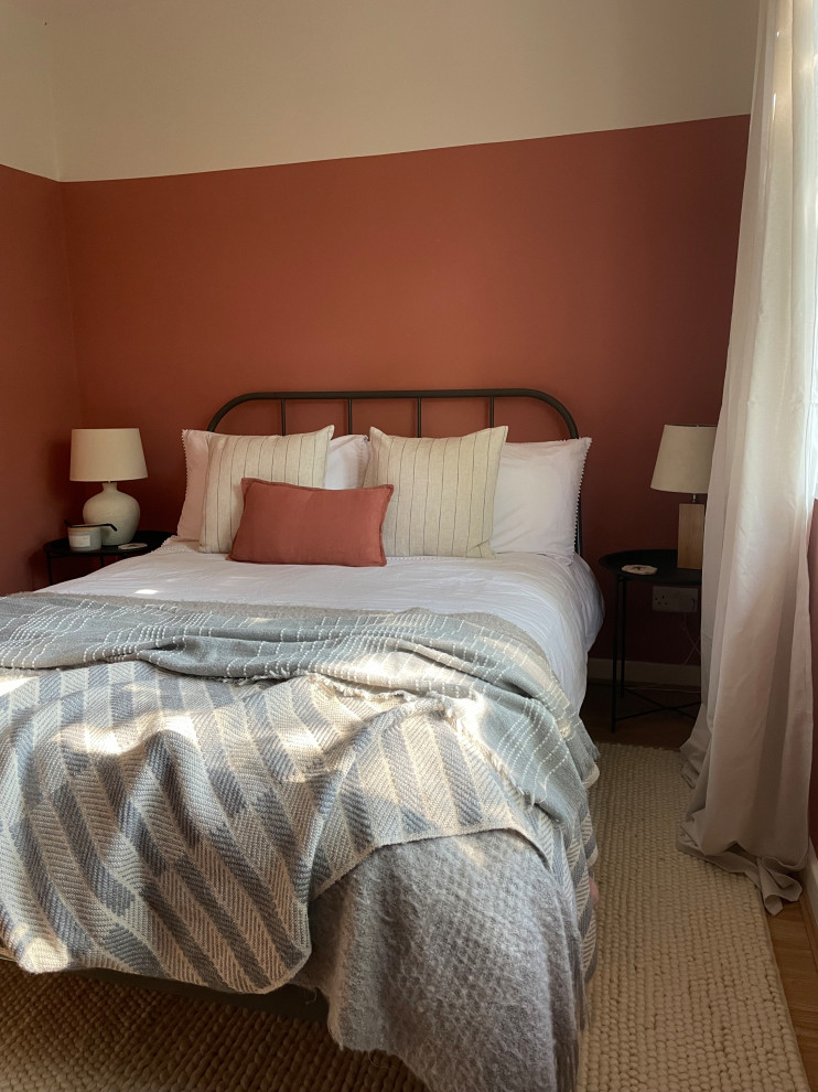 Идея дизайна: маленькая гостевая спальня (комната для гостей) в средиземноморском стиле с розовыми стенами, полом из ламината и коричневым полом для на участке и в саду