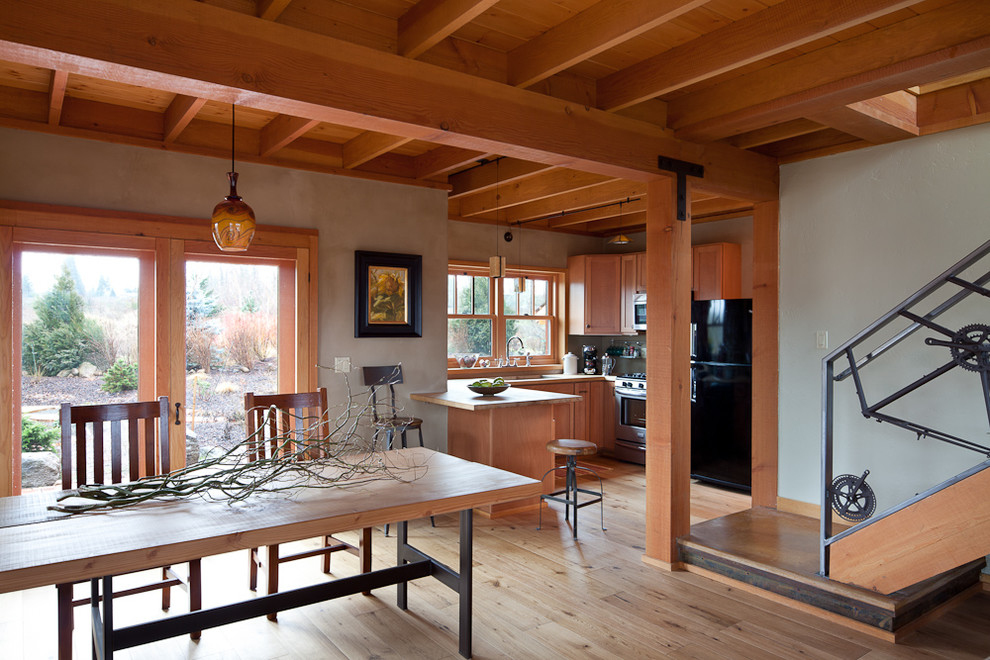 Mid-sized country kitchen/dining combo in Portland with grey walls, light hardwood floors and brown floor.