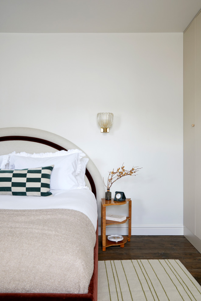 This is an example of a medium sized eclectic master bedroom in London with white walls, dark hardwood flooring and brown floors.