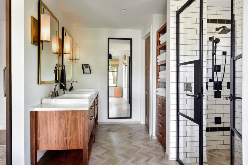 Mid-sized transitional master bathroom with medium wood cabinets, a freestanding tub, an alcove shower, white tile, subway tile, white walls, a vessel sink, beige floor and white benchtops.