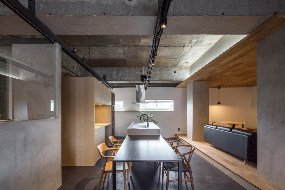 Photo of a mid-sized industrial open plan dining in Tokyo Suburbs with grey walls, concrete floors, grey floor and wallpaper.