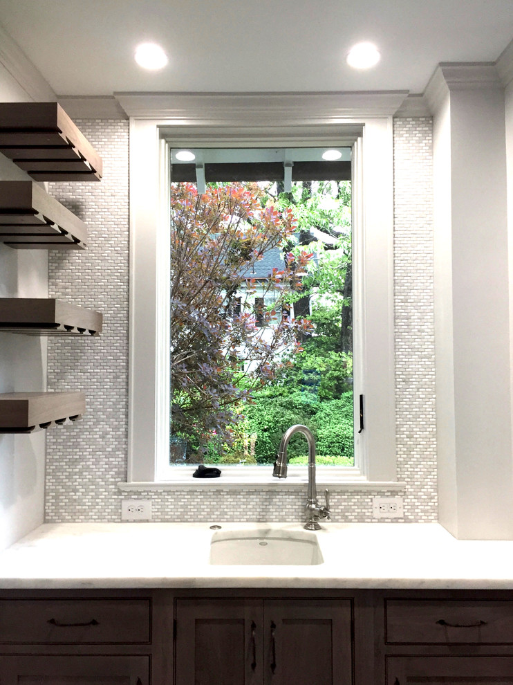 Inspiration for a transitional ceramic tile kitchen remodel with an undermount sink, shaker cabinets, medium tone wood cabinets, marble countertops, white backsplash, ceramic backsplash and an island