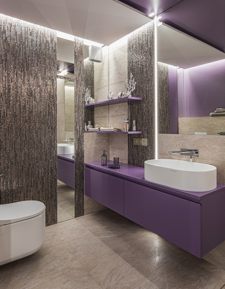 Cette image montre une salle de bain principale design de taille moyenne avec un placard à porte plane, des portes de placard violettes, une douche d'angle, WC suspendus, un carrelage beige, des carreaux de porcelaine, un mur violet, un sol en carrelage de porcelaine, un lavabo posé, un plan de toilette en verre, un sol beige, une cabine de douche à porte battante, un plan de toilette violet, meuble-lavabo suspendu, un plafond en papier peint et du papier peint.