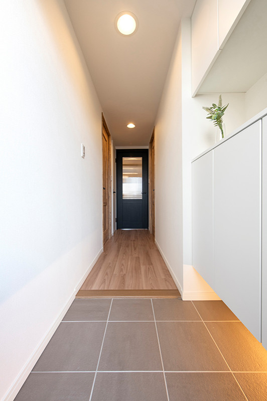 Свежая идея для дизайна: коридор среднего размера в скандинавском стиле с белыми стенами, полом из фанеры, коричневым полом, потолком с обоями и обоями на стенах - отличное фото интерьера