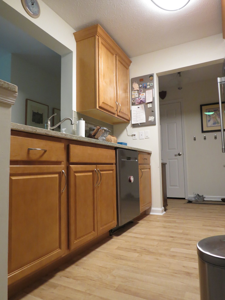 Inspiration for a small transitional galley vinyl floor and brown floor enclosed kitchen remodel with an undermount sink, raised-panel cabinets, light wood cabinets, quartz countertops, beige backsplash, glass tile backsplash, stainless steel appliances, no island and beige countertops