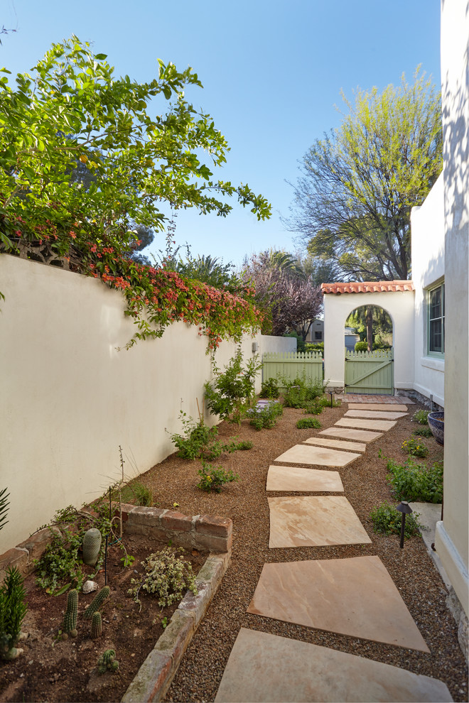 Mid-sized side yard partial sun xeriscape in Phoenix with natural stone pavers for spring.