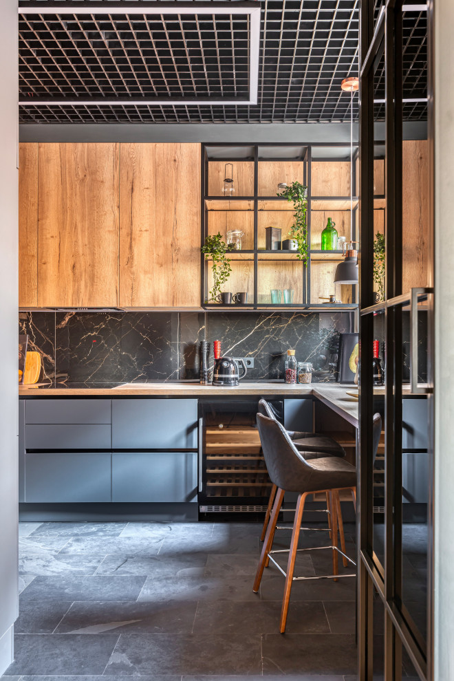 Inspiration for a medium sized contemporary grey and brown galley enclosed kitchen in Moscow with a submerged sink, flat-panel cabinets, black cabinets, wood worktops, black splashback, porcelain splashback, black appliances, marble flooring, an island and brown worktops.