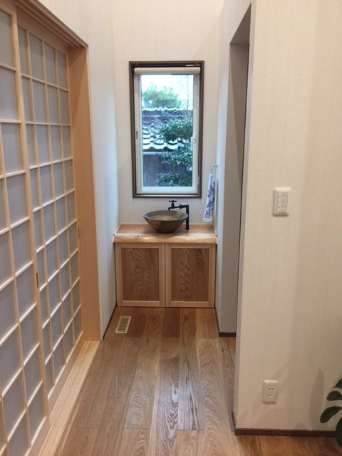 Mid-sized asian powder room in Other with beaded inset cabinets, light wood cabinets, a one-piece toilet, multi-coloured tile and wood benchtops.