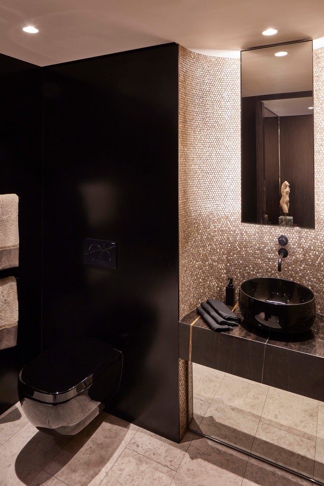 Small contemporary 3/4 bathroom in Sydney with glass-front cabinets, a double shower, a wall-mount toilet, multi-coloured tile, mosaic tile, multi-coloured walls, limestone floors, a vessel sink, marble benchtops, beige floor, a hinged shower door and black benchtops.
