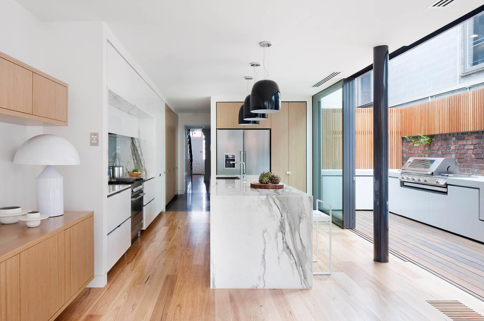 Design ideas for a contemporary kitchen in Melbourne with flat-panel cabinets, medium wood cabinets, stainless steel appliances, with island and white benchtop.
