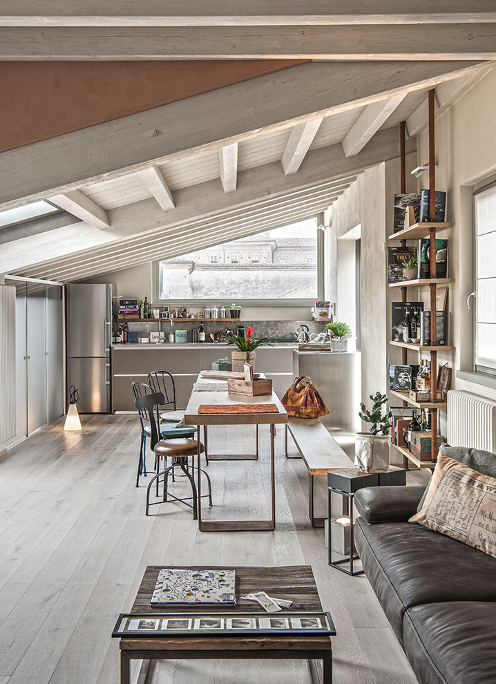 Photo of an industrial open plan dining in Milan with beige walls, light hardwood floors and grey floor.