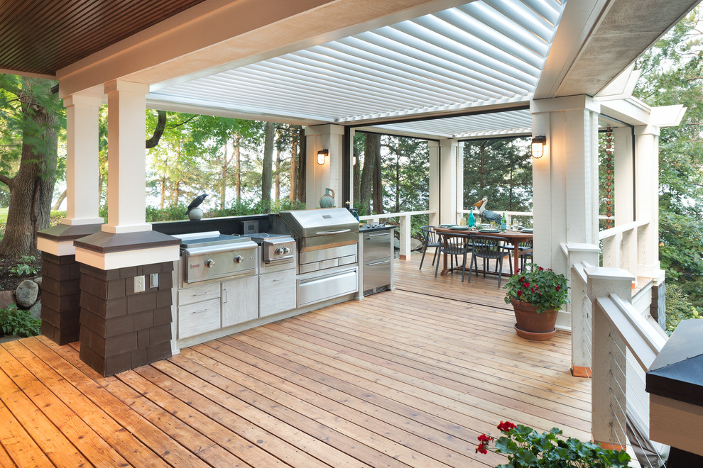 Large beach style backyard deck in Minneapolis with an outdoor kitchen and a pergola.
