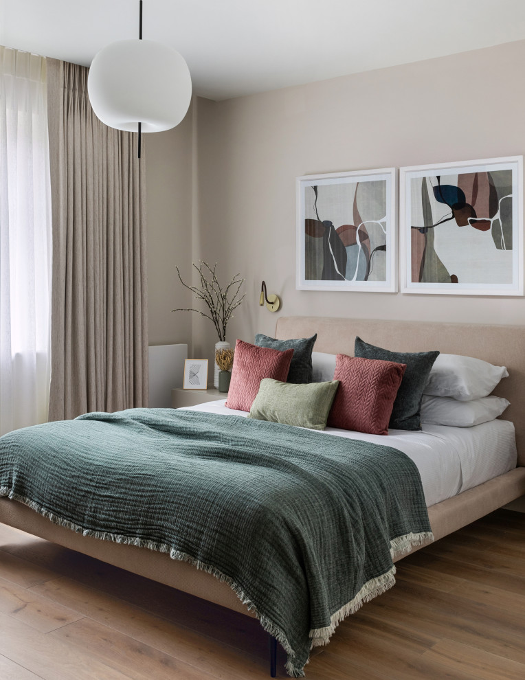 Ispirazione per una camera degli ospiti minimal di medie dimensioni con pareti beige e pavimento in legno massello medio