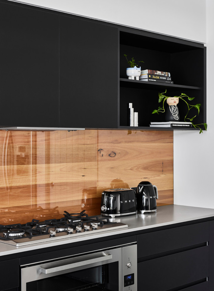 Design ideas for a mid-sized modern galley eat-in kitchen in Sunshine Coast with an undermount sink, black cabinets, concrete benchtops, timber splashback, stainless steel appliances, concrete floors, with island, green floor and white benchtop.