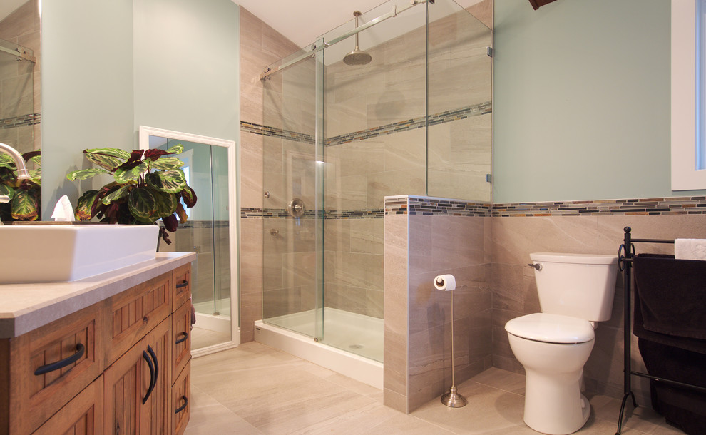 Large traditional master bathroom in Vancouver with shaker cabinets, medium wood cabinets, a double shower, a two-piece toilet, beige tile, porcelain tile, blue walls, porcelain floors, a trough sink and laminate benchtops.