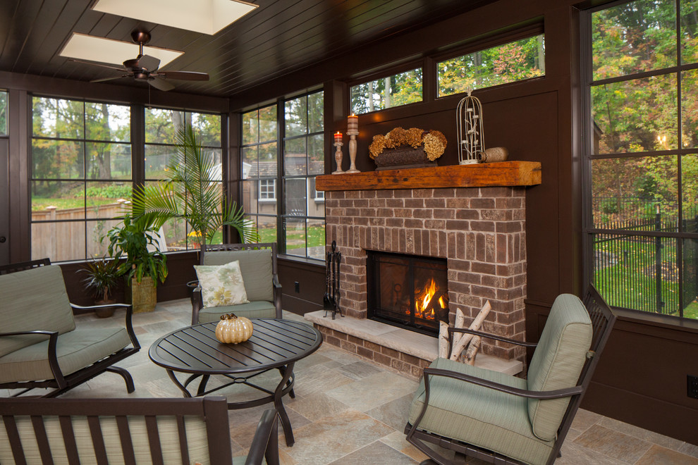 Design ideas for a large traditional sunroom in Toronto with travertine floors, a standard fireplace, a brick fireplace surround, a skylight and beige floor.