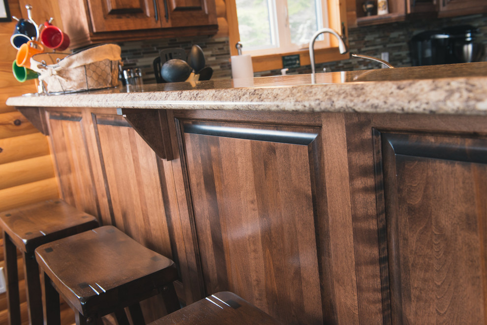 Home design - mid-sized rustic l-shaped dark wood floor and brown floor home design idea with raised-panel cabinets, medium tone wood cabinets, laminate countertops, multicolored backsplash, stainless steel appliances, a peninsula and beige countertops