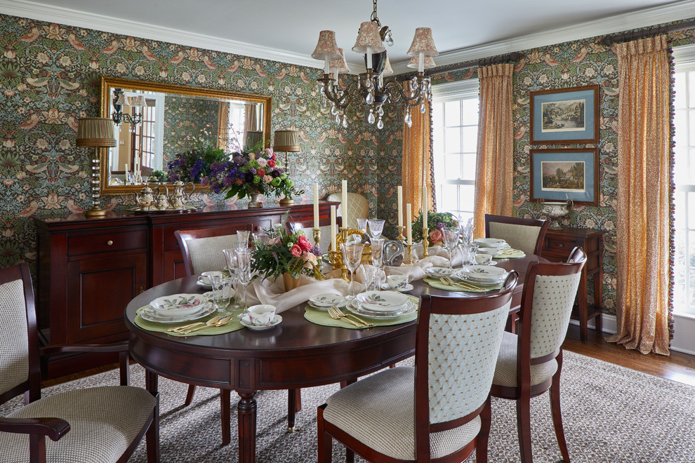 Traditional Rumson Home - A traditional enclosed dining room receives a dramatic transformation with a William Morris bird patterened wallpaper in green, blue and pinks. Custom pinched pleat drapery panels are created with a coordinating William Morris leaf pattern fabric and tri-colored tassel fringe. The client's dining room set maintained in the space. The surrounding dining chairs and flanking accent chairs all were re-upholstered in coordinating textures and tight patterned fabrics.