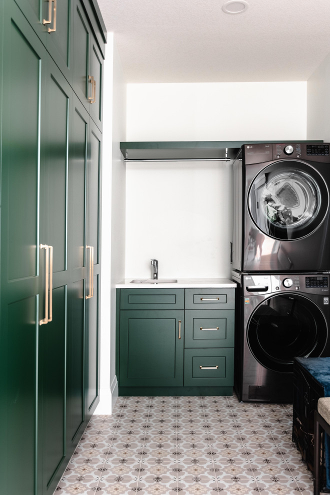 Esempio di una grande sala lavanderia moderna con lavello sottopiano, ante verdi, top in quarzo composito, pareti bianche, lavatrice e asciugatrice a colonna e top bianco