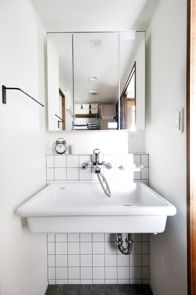 Asian powder room in Tokyo with white tile, white walls, a wall-mount sink and grey floor.