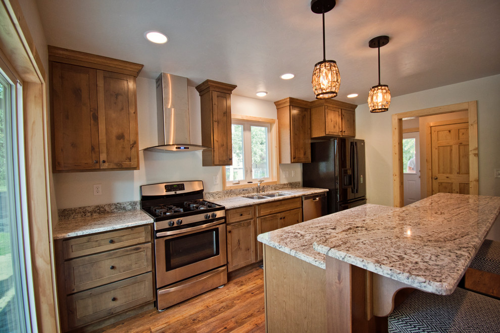 Eat-in kitchen - mid-sized rustic galley medium tone wood floor and brown floor eat-in kitchen idea with a double-bowl sink, recessed-panel cabinets, brown cabinets, granite countertops, stainless steel appliances, an island and beige countertops