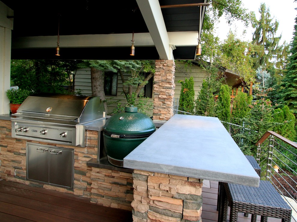 Backyard outdoor kitchen deck photo in Seattle with a roof extension
