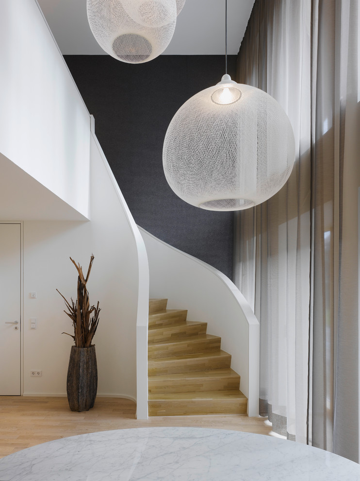 Design ideas for a mid-sized contemporary wood curved staircase in Stuttgart with wood risers.