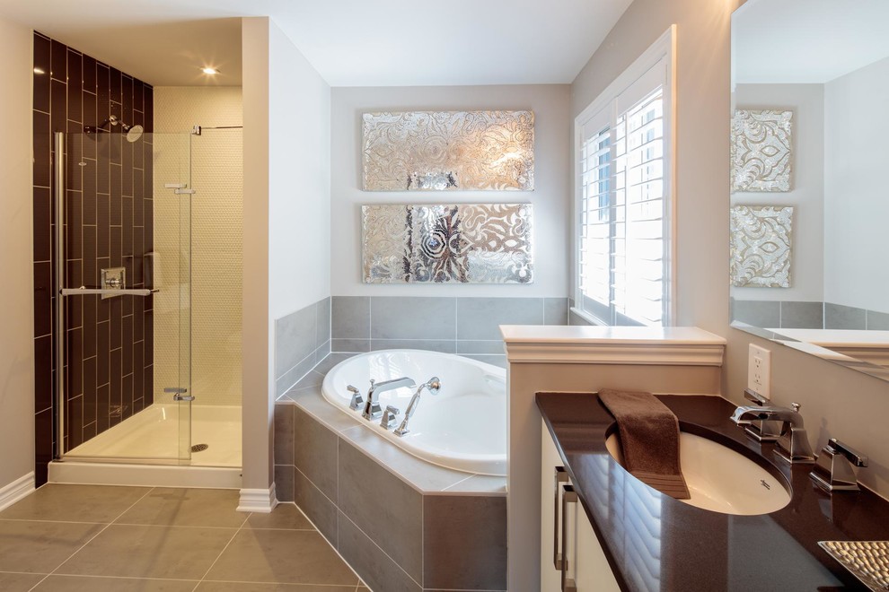 Inspiration for a large transitional master bathroom in Ottawa with flat-panel cabinets, white cabinets, a drop-in tub, an alcove shower, gray tile, ceramic tile, white walls, ceramic floors, an undermount sink, marble benchtops and brown benchtops.