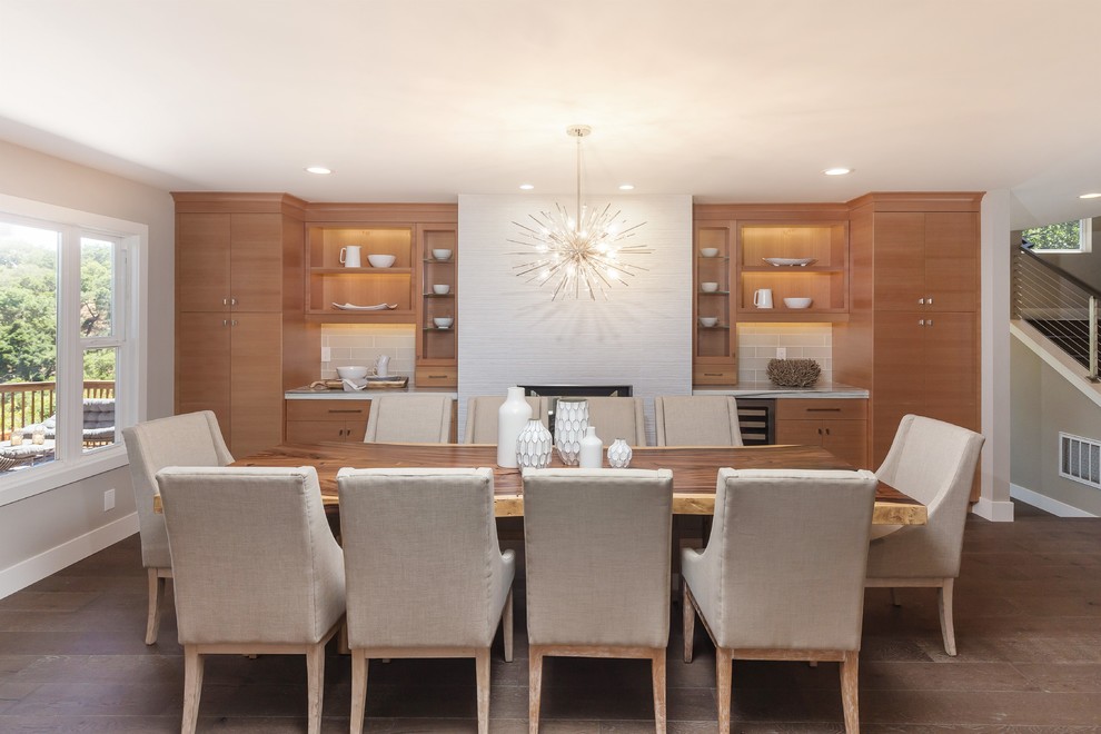 Inspiration for a mid-sized contemporary separate dining room in San Francisco with grey walls, light hardwood floors, a standard fireplace, a concrete fireplace surround and brown floor.