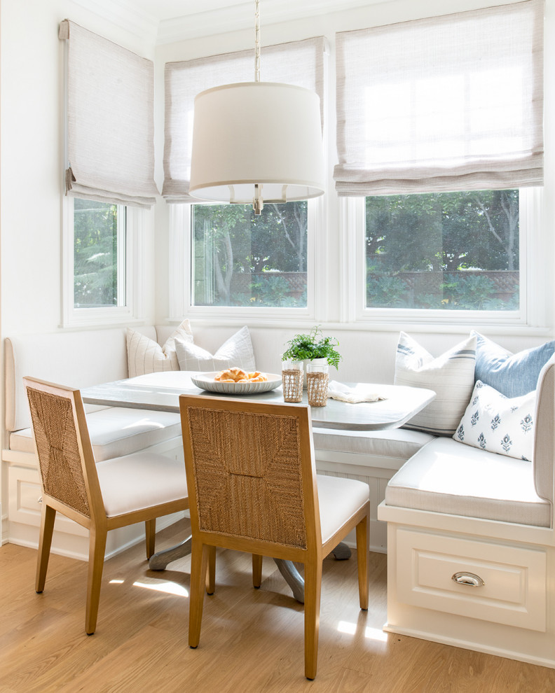 Inspiration for a classic dining room in Los Angeles with banquette seating and white walls.