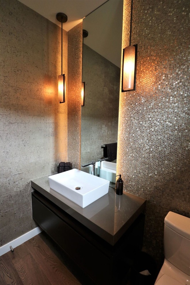 Mid-sized contemporary powder room in Vancouver with flat-panel cabinets, black cabinets, a one-piece toilet, gray tile, mosaic tile, grey walls, dark hardwood floors, a vessel sink, engineered quartz benchtops, brown floor and grey benchtops.